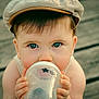 baby, infant, bottle, cap, blue_eyes, close_up, cute, child, drinking, face, hands, wooden_floor, outdoor, portrait, skin, young, person, casual, headwear, holding