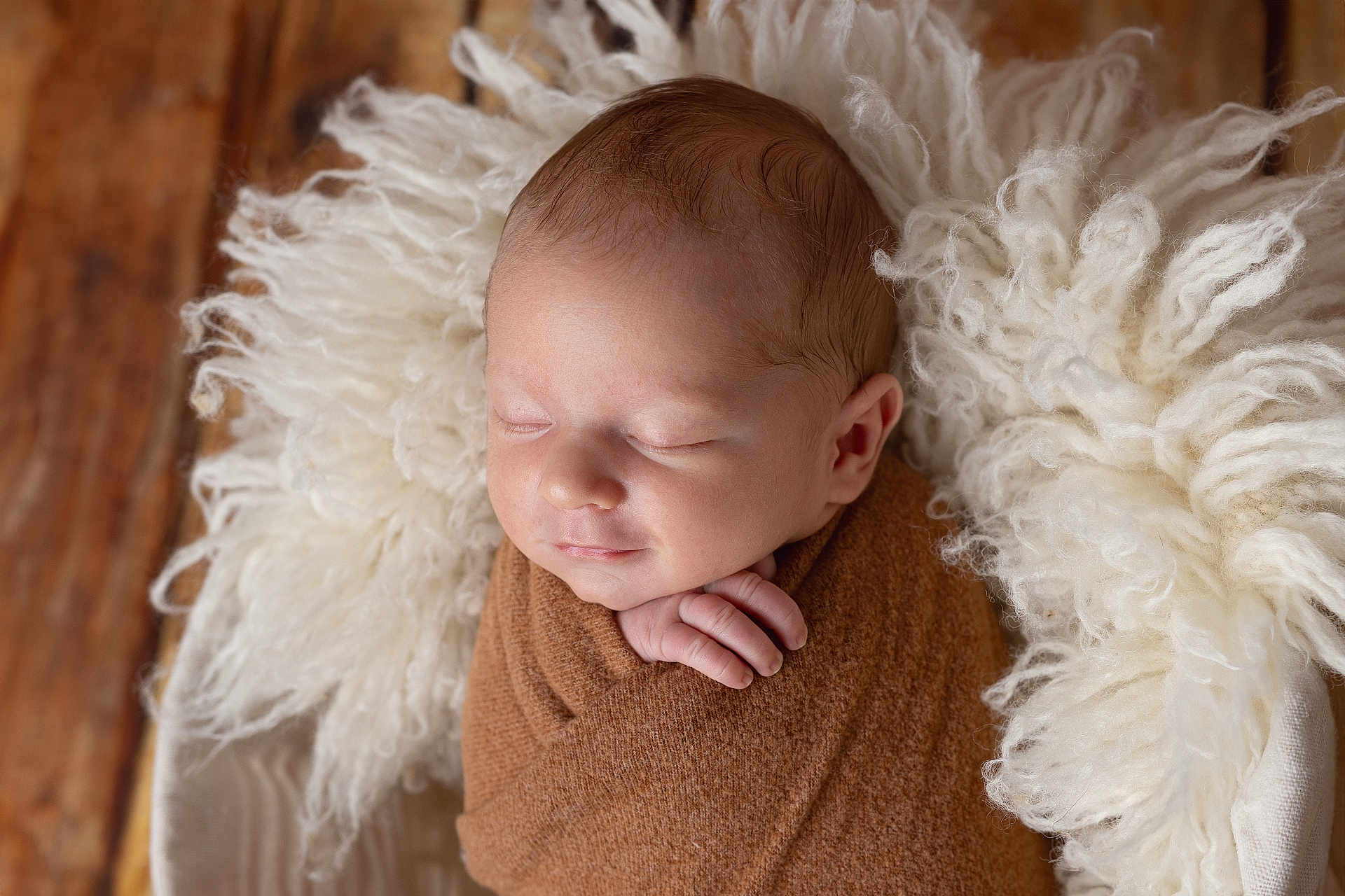 Thibault a rejoint le concours — aidez-le/la à gagner de superbes lots ! newborn, baby, infant, sleeping, wrapped, blanket, brown, white, fluffy, cushion, wooden_floor, peaceful, cute, portrait, closeup, soft_texture, resting, indoors, child, hands