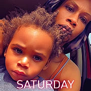Ozias joined the competition — help win amazing prizes! child, adult, portrait, car, sunlight, headscarf, clothing, person, face, serious, indoors, window, sitting, shoulder, hair, expression, casual, text_overlay, daytime, family