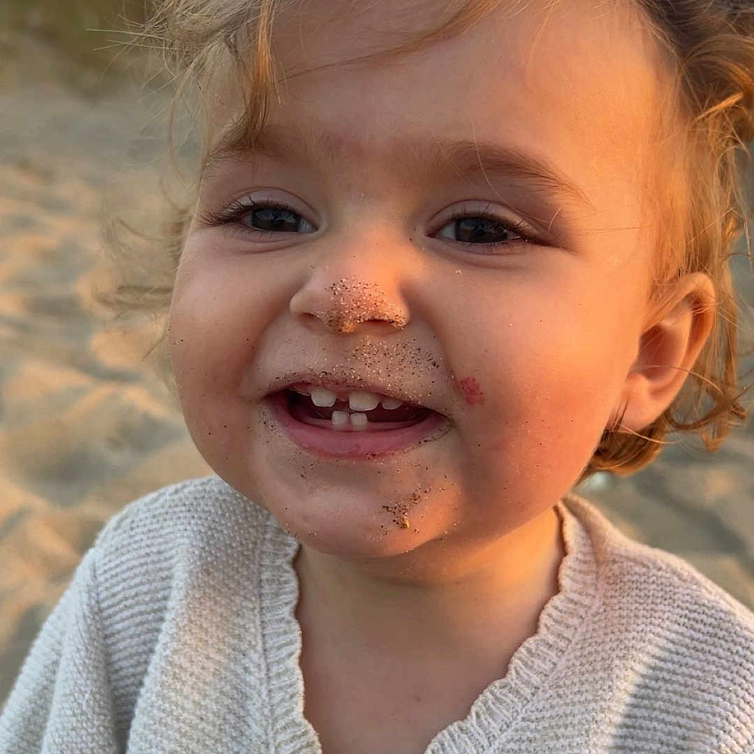Mia participe au concours pour gagner de l'argent avec cette photo : beach, child, childhood, close_up, curly_hair, cute, face, golden_hour, happy, knitted_sweater, nature, outdoor, portrait, sandy_face, skin, smile, sunset, toddler, warm_light, young
