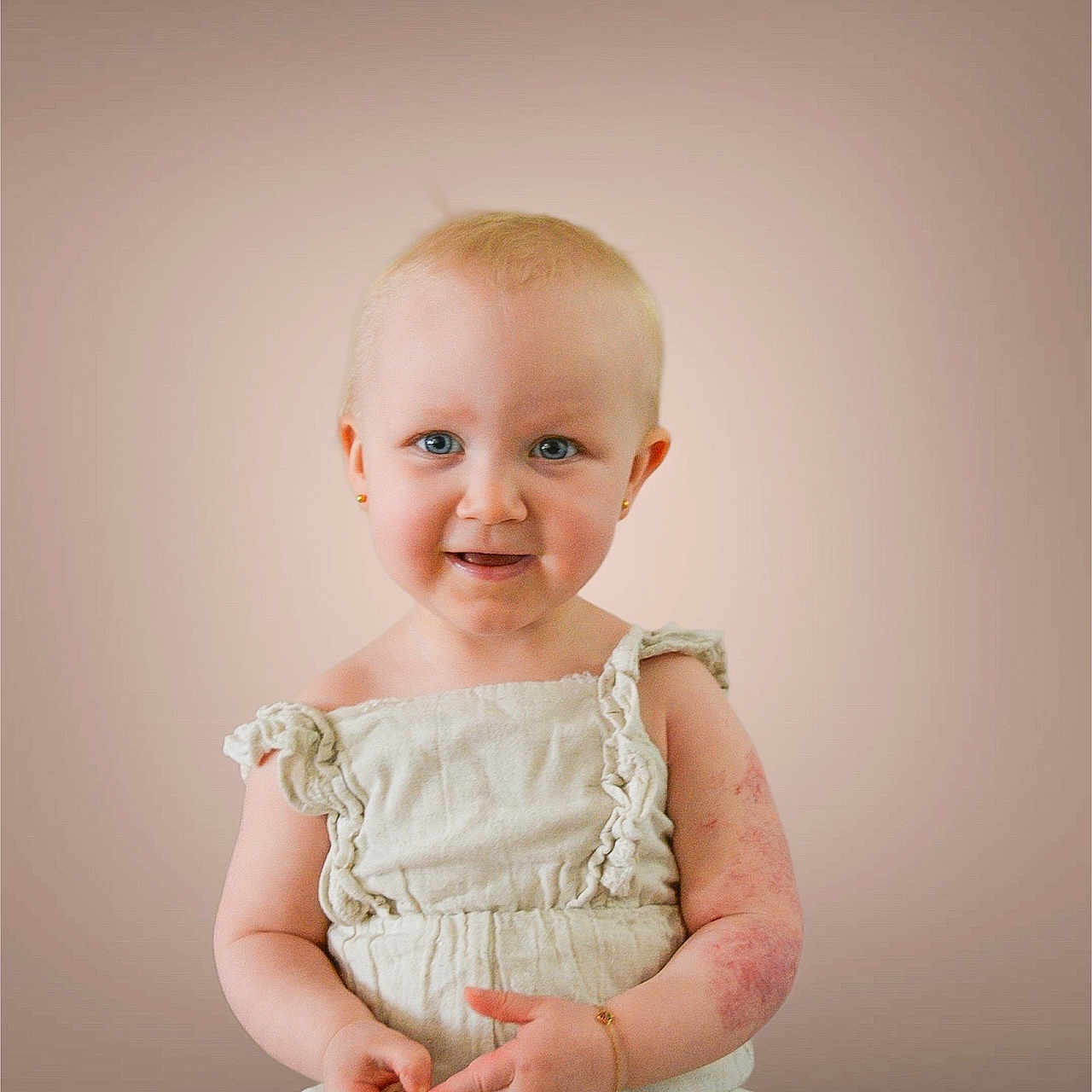Charlie participe au concours pour gagner de l'argent avec cette photo : baby, child, portrait, smile, blue_eyes, earrings, bracelet, cream_outfit, sitting, cute, infant, face, skin_mark, young_child, studio_background, one_person, looking_at_camera, innocent, happy, soft_lighting