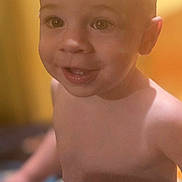 Hudson is registered to the contest to win money with this photo: toddler, child, smile, face, bare_chest, young_child, portrait, indoors, warm_lighting, yellow_background, happy, cute, baby, skin, head, eyes, young, expression, person, human