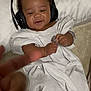 Kaiden Aka Kg joined the competition — help win amazing prizes! baby, headphones, white_clothing, smiling, hand, finger, bed, pillow, infant, cute, child, lying_down, indoors, skin, expression, music, head, person, young_child, cozy