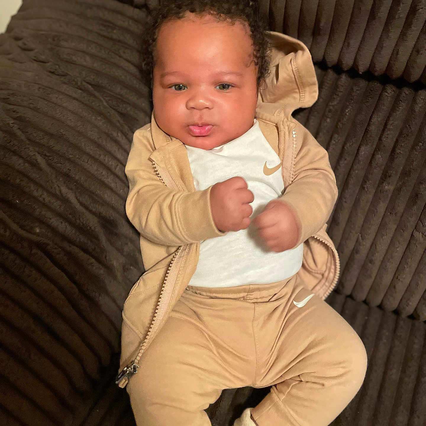 Kaiden Aka Kg is registered to the contest to win money with this photo: baby, child, clothing, comfort, couch, curly_hair, cute, face, fist, indoor, infant, jacket, nike, pants, plush_furniture, portrait, relaxed, seated, socks, young_child