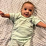 baby, child, infant, mickey_mouse, smiling, happy, lying_down, blanket, soft_texture, clothing, shorts, tshirt, cute, portrait, indoors, person, young_child, face, expression, playful