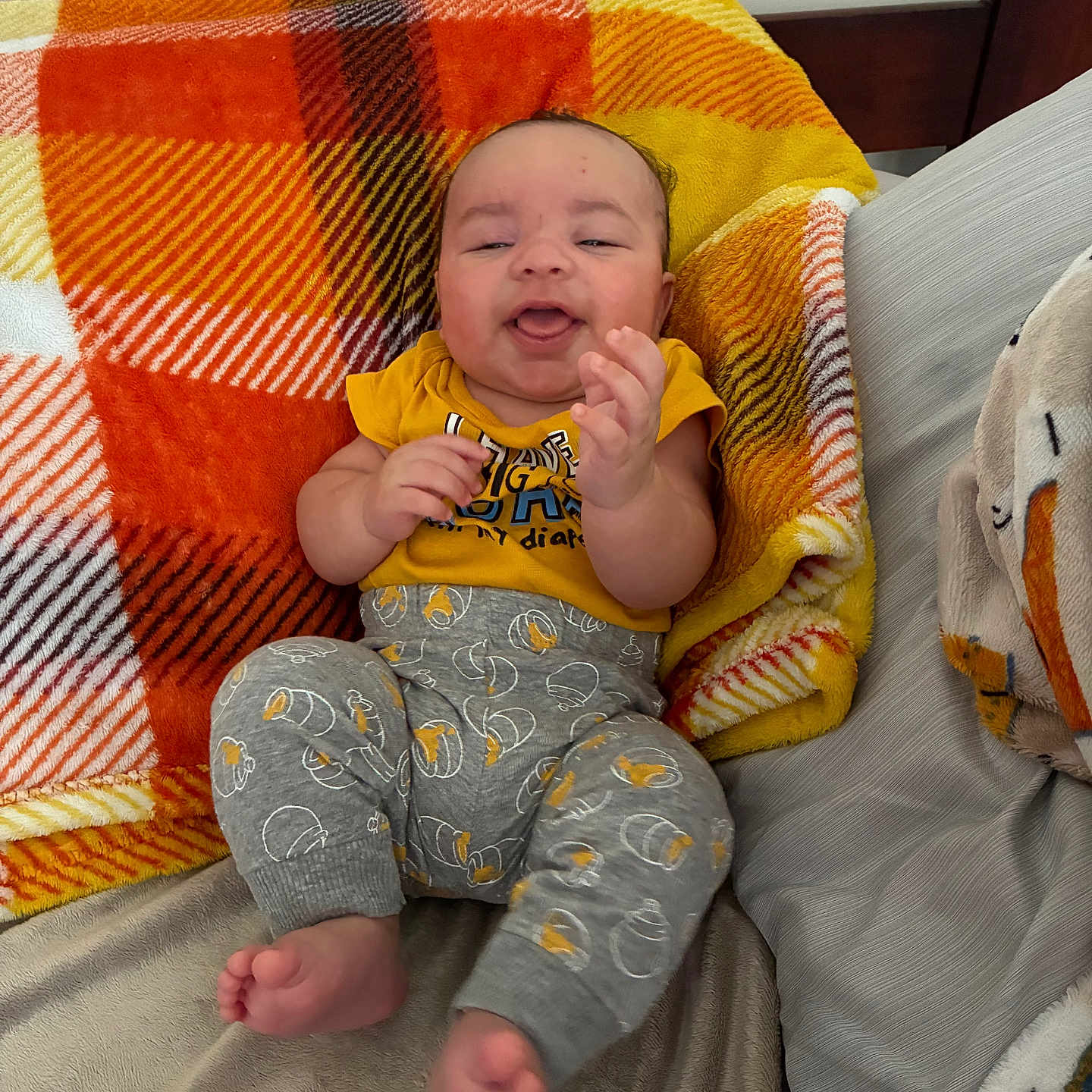 Papalovy joined the competition — help win amazing prizes! baby, bed, blanket, clothing, cushion, cute, feet, furniture, gray_pants, hands, happy, head, indoors, infant, orange, person, plaid, smiling, yellow, yellow_shirt