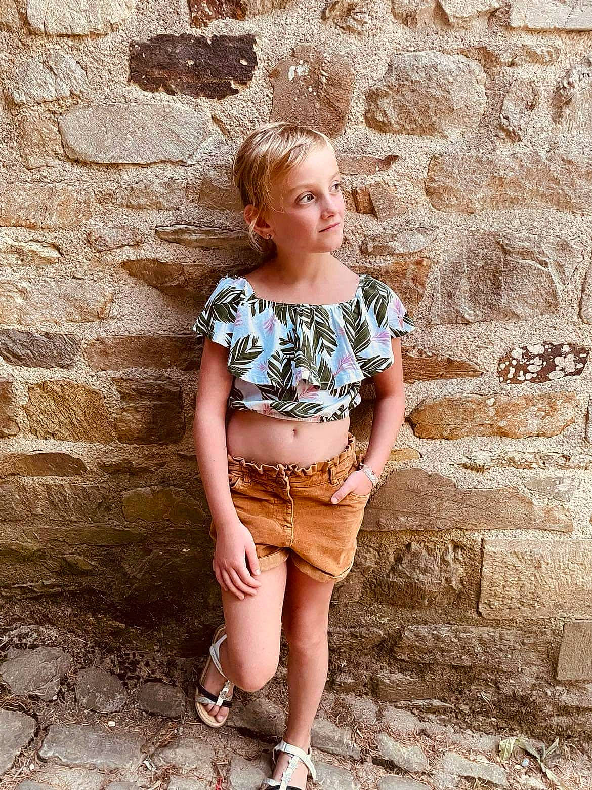 Kyllin participe au concours pour gagner de l'argent avec cette photo : abdomen, arm, blond, brick, denim, flash_photography, hair, happy, human_leg, jewellery, knee, long_hair, neck, person, shorts, standing, t_shirt, thigh, trunk, waist