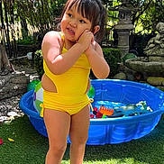 Angelina joined the competition — help win amazing prizes! barefoot, blue_pool, child, flowers, garden, grass, greenery, happy, nature, outdoor, person, playful, portrait, stone_sculpture, summer, sunlight, toddler, toys, water_play, yellow_swimsuit