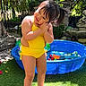 Angelina joined the competition — help win amazing prizes! barefoot, child, cute_pose, daytime, flowers, garden, grass, greenery, happy, kiddie_pool, nature, outdoor, person, playtime, smiling, summer, sunlight, toddler, toys, yellow_swimsuit