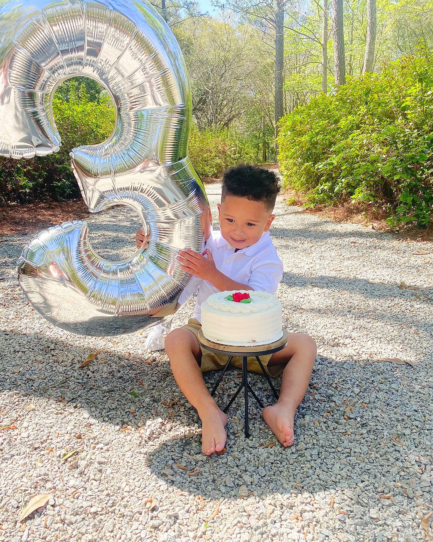 Ashton is registered to the contest to win money with this photo: automotive_tire, automotive_wheel_system, barefoot, foot, fun, garden, grass, happy, joy, landscape, leaf, leisure, person, plant, recreation, rock, shorts, sitting, t_shirt, toddler