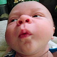 Michael is registered to the contest to win money with this photo: baby, closeup, face, cheeks, expression, puckered_lips, infant, bottle, pillow, animal_print, green, blanket, soft, indoors, skin, head, neck, clothing, cute, child
