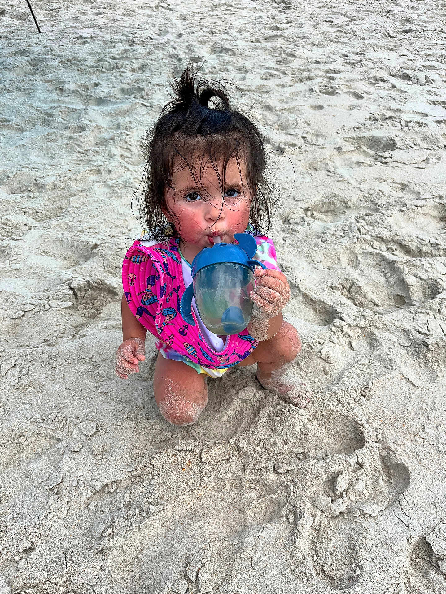 Violetta joined the competition — help win amazing prizes! child, toddler, beach, sand, sippy_cup, floatation_vest, messy_hair, pony_tail, sitting, drinking, outdoor, play, summer, water_toy, footprints, curious, cute, sun_kissed, vacation, fun