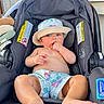 baby, child, car_seat, hat, bare_chest, shorts, foot, hand, face, skin, indoors, seat, clothing, person, infant, cute, sitting, summer, relaxing, sunhat