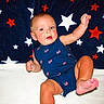 Holden is registered to the contest to win money with this photo: baby, infant, child, blue_outfit, stars, blanket, pattern, flag_print, patriotic, cute, smiling, sitting, foot, hand, indoor, portrait, happy, skin, face, young
