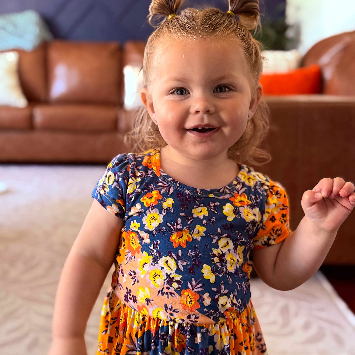 Hadley Dawn is registered to the contest to win money with this photo: child, girl, smiling, portrait, indoor, living_room, dress, floral_pattern, hair_tied, cute, happy, person, fashion, young_child, home, couch, carpet, colorful, standing, playful