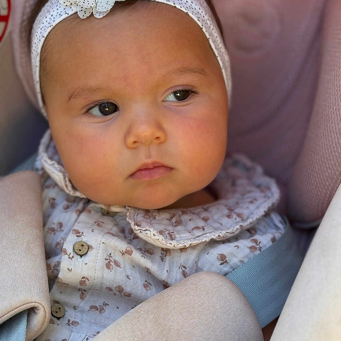 Lesia a rejoint le concours — aidez-le/la à gagner de superbes lots ! baby, baby_girl, car_seat, child, closeup, clothing, comfort, cute, face, flower, headband, indoors, infant, patterned_clothing, person, portrait, seatbelt, serene, soft_lighting, young_child