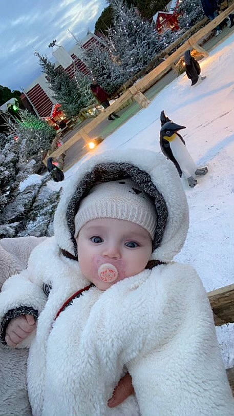 Célya a rejoint le concours — aidez-le/la à gagner de superbes lots ! baby, beanie, cap, child, christmas, cloud, event, freezing, fun, fur, fur_clothing, happy, headwear, holiday, person, plant, sky, snow, toddler, tree