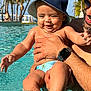 baby, child, man, pool, water, splashing, sunny, hat, bucket_hat, swim_diaper, palm_trees, outdoor, summer, vacation, happy, smiling, adult, sunglasses, watch, skin