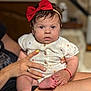 Myanna a rejoint le concours — aidez-le/la à gagner de superbes lots ! adult_hand, baby, buttoned_shirt, child, clothing, cute, expression, fingernails, foot, hand, headband, holding, indoor, person, portrait, red_bow, sitting, skin, toes, yellow_nail_polish