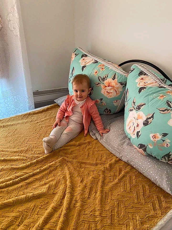 Sophie a rejoint le concours — aidez-le/la à gagner de superbes lots ! baby, baby_toddler_clothing, bed_sheet, bedding, child, comfort, floor, flooring, hardwood, joy, leg, linens, outerwear, pattern, person, skin, sleeve, smile, t_shirt, textile