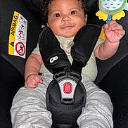 Abel participe au concours pour gagner de l'argent avec cette photo : baby, car_seat, child, toy, smile, curly_hair, safety_harness, infant, cute, holding, clothing, pacifier, happy, indoor, seat_belt, colorful_toy, person, close_up, portrait, baby_toy