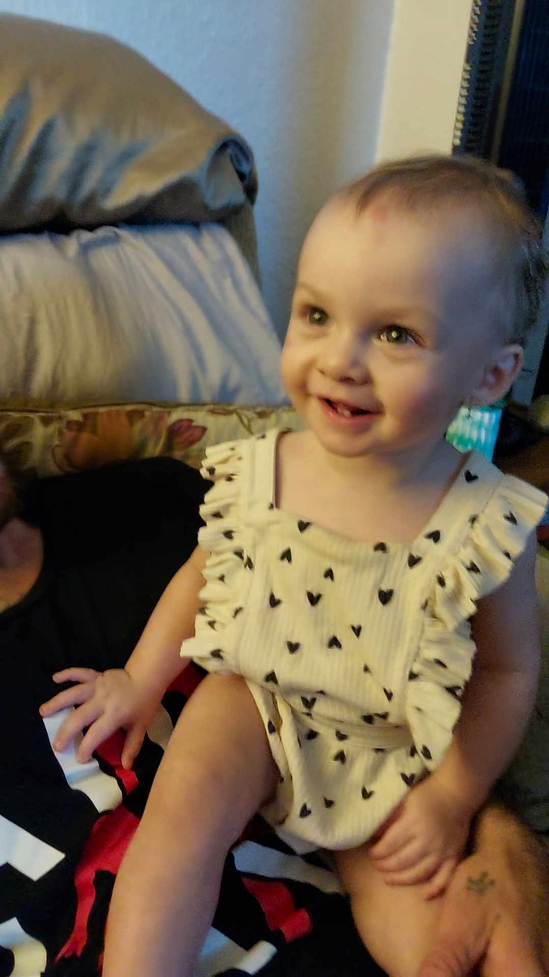 Serenity is registered to the contest to win money with this photo: toddler, child, smile, sitting, couch, clothing, heart_pattern, person, hand, face, indoors, wall, cushion, happy, baby, cute, portrait, blurred, light, skin