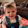 baby, child, smiling, headband, blue_eyes, denim_overalls, toy, dumbbell_toy, activity_center, blanket, living_room, couch, indoor, person, cute, happy, infant, playtime, pink_blanket, colorful_toys