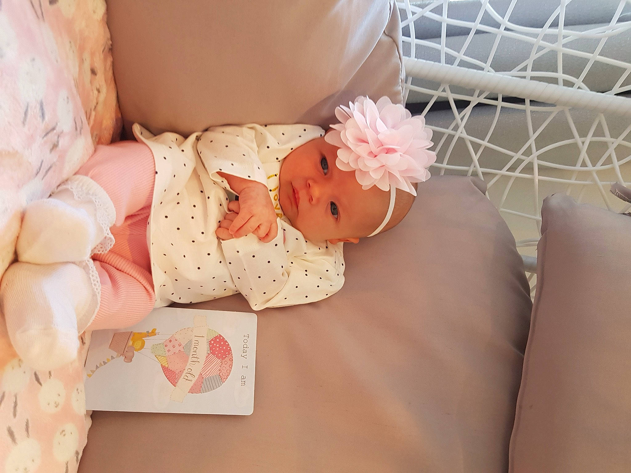 Kiara is registered to the contest to win money with this photo: baby, child, ear, fashion_accessory, furniture, hair_accessory, headband, headwear, leg, peach, person, pillow, pink, room, textile, toddler