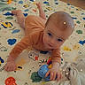 baby, infant, playmat, toy, blanket, floor, indoor, child, cute, reaching, animal_prints, blue_toy, soft_lighting, cozy, curious, lying_down, home, person, small_hands, sparkles