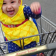 Arya joined the competition — help win amazing prizes! baby, barefoot, blue_clothing, building, child, costume, fun, hand_raised, happy, metal_cart, outdoor, parking_lot, pineapple, polka_dots, shopping_cart, sidewalk, smiling, tongue_out, urban, yellow