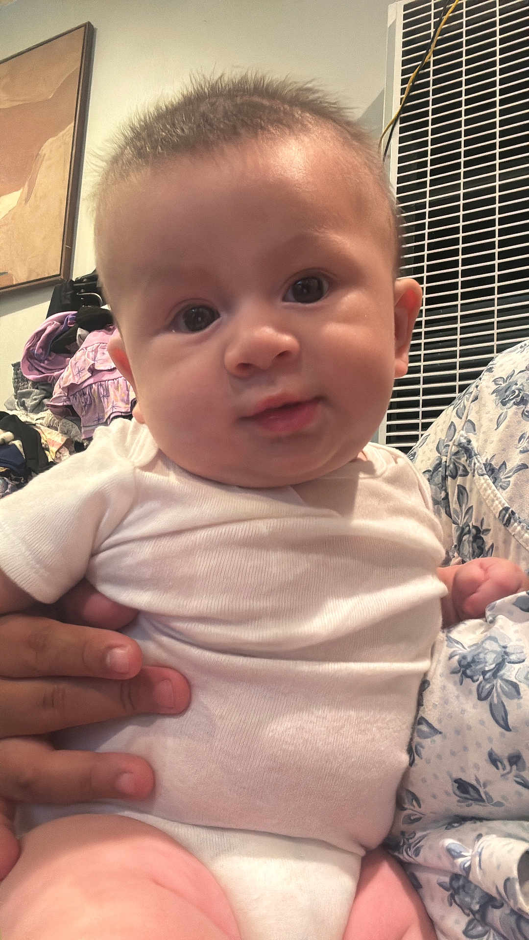 David joined the competition — help win amazing prizes! baby, child, infant, white_clothing, curious_look, chubby_cheeks, hand, indoor, pile_of_clothes, floral_pattern, face, person, cute, skin, portrait, holding, newborn, soft_light, closeup, young_baby