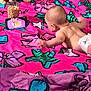 baby, diaper, blanket, smartphone, cereal, glass, stuffed_animal, floor, indoor, colorful, pink, purple, watching, lying_down, curious, infant, toy, playtime, child, casual