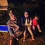 child, children, outdoor, night, grass, hat, beanie, jacket, sweater, boots, playing, friends, smiling, sitting, cold_weather, toy, chair, dark, happy