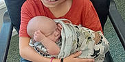 Mckinley is registered to the contest to win money with this photo: child, baby, smiling, holding, blanket, chair, indoor, happy, face, person, sitting, clothing, shorts, hair, skin, furniture, comfort, love, family, peaceful