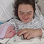 newborn, baby, mother, hospital_bed, hospital_gown, blanket, face, person, infant, love, family, newborn_hat, hand, bed, healthcare, smile, skin, human, hospital, comfort