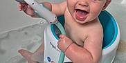 Jaxon is registered to the contest to win money with this photo: baby, bathtub, bath_seat, bath_toy, foam, water, child, smiling, happy, indoor, skin, blue, white, toy, playing, sitting, cute, childcare, cleaning, bath_time