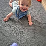 Jaxon is registered to the contest to win money with this photo: baby, child, crawling, carpet, blue_eyes, blonde_hair, bib, striped_clothing, toy, plastic_toy, indoor, floor, happy, smiling, curly_hair, playful, infant, person, cute, toddler