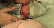 Azrael is registered to the contest to win money with this photo: newborn, baby, adult, kiss, hat, knit_hat, sleeping, tattoo, hand, blanket, closeup, face, love, tenderness, family, skin, person, indoor, cozy, affection