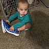baby, baby_gate, blue_shoes, blur, carpet, child, clothing, curious, diaper, floor, footwear, furniture, home, indoor, motion, person, sitting, sneakers, toddler, toy