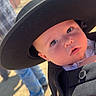 baby, hat, face, outdoor, sunlight, person, child, carrier, black_hat, curious, portrait, clothing, shadow, daylight, closeup, young_child, expression, casual, background, human