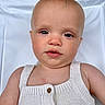Reuben is registered to the contest to win money with this photo: baby, child, infant, face, skin, knitted_clothing, white_background, portrait, closeup, button, expression, head, eyes, nose, mouth, shoulder, arm, soft_light, texture, young