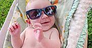 Nolan is registered to the contest to win money with this photo: baby, infant, child, smiling, sunglasses, outdoor, chair, blanket, cushion, portrait, happy, casual, summer, grass, garden, seated, clothing, shorts, playful, photography
