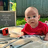 Nolan joined the competition — help win amazing prizes! baby, infant, child, portrait, outdoor, grass, backyard, smiling, curious, red_shirt, toy_truck, tools, wrench, workbench, blanket, milestone_board, five_months, sitting, sunlight, family_photo