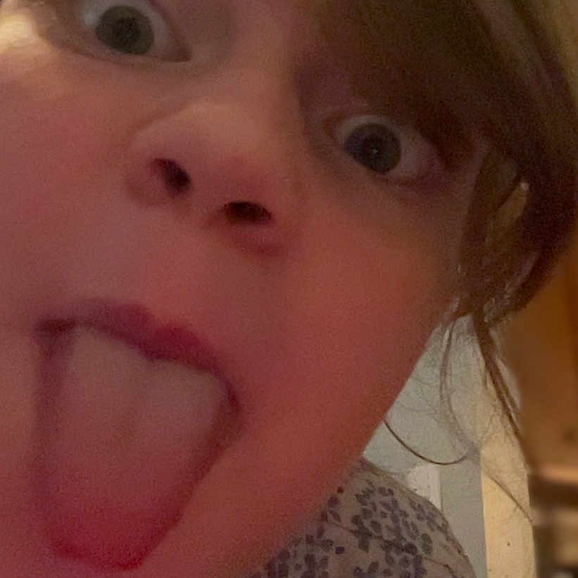 Ellieana joined the competition — help win amazing prizes! child, face, tongue, expression, silly, closeup, hair, indoor, portrait, person, young, shirt, floral_pattern, funny_face, playful, wide_eyes, messy_hair, skin, head, casual