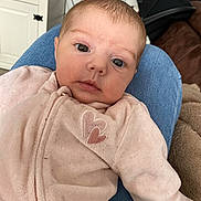 Melya participe au concours pour gagner de l'argent avec cette photo : baby, infant, face, eyes, pajamas, heart_patch, clothing, person, indoor, home, jeans, lap, furniture, couch, blanket, soft, cute, child, portrait, resting