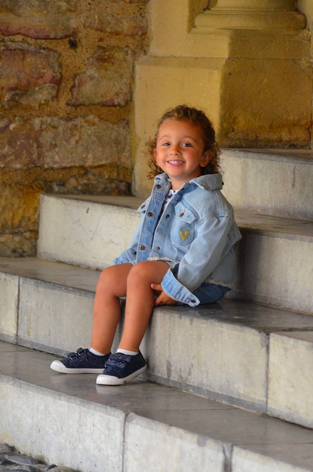 Margaux participe au concours pour gagner de l'argent avec cette photo : azure, brick, child, denim, electric_blue, fashion, grey, happy, human_leg, joint, joy, knee, leg, leisure, person, smile, standing, street_fashion, t_shirt, temple