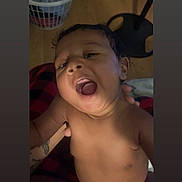 Jason is registered to the contest to win money with this photo: baby, infant, child, portrait, indoor, supported, adult_hand, open_mouth, facial_expression, bare_chest, sitting, close_up, hair, eyes, nose, mouth, laundry_basket, chair, blanket, home