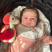 Giulia a rejoint le concours — aidez-le/la à gagner de superbes lots ! baby, infant, child, blanket, stuffed_toy, pink_clothing, cushion, soft_toy, face, portrait, indoors, pout, cute, pajamas, baby_bib, hair_tie, light, expression, comfort, closeup