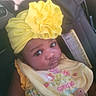 adorable, baby, bib, car_seat, child, closeup, clothing, cute, floral, flower, headwrap, indoor, infant, person, portrait, seatbelt, smile, warm_light, yellow, young_child