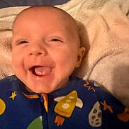 Syrus joined the competition — help win amazing prizes! baby, smiling, laughing, infant, blanket, blue_clothing, space_theme, rocket, stars, face, head, cheerful, cute, soft_texture, happy, child, sleepwear, cozy, lying_down, person